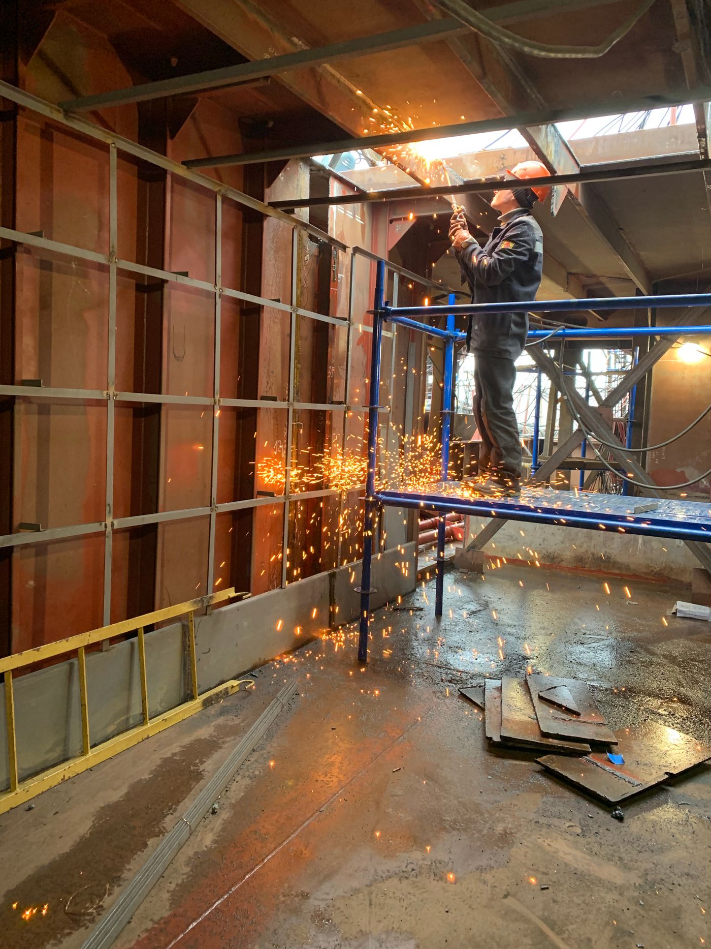 Welder sending sparks across a factory floor