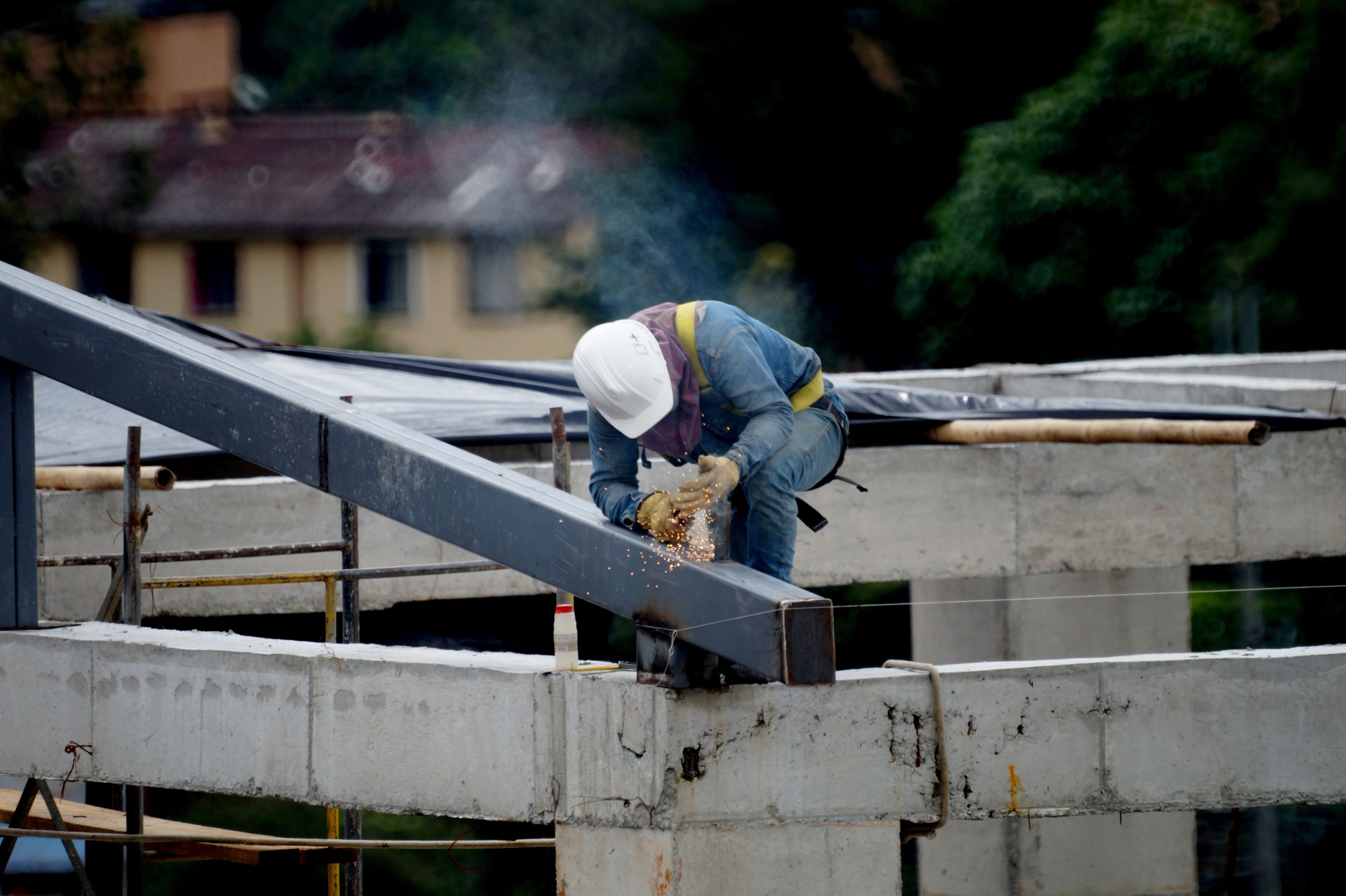 Construction worker welding structural steel at a contractor job site