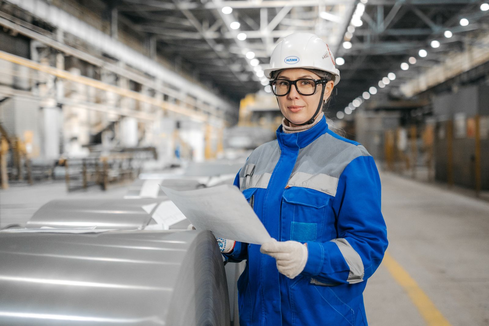 Engineer reviewing documents on the floor of an industrial plant