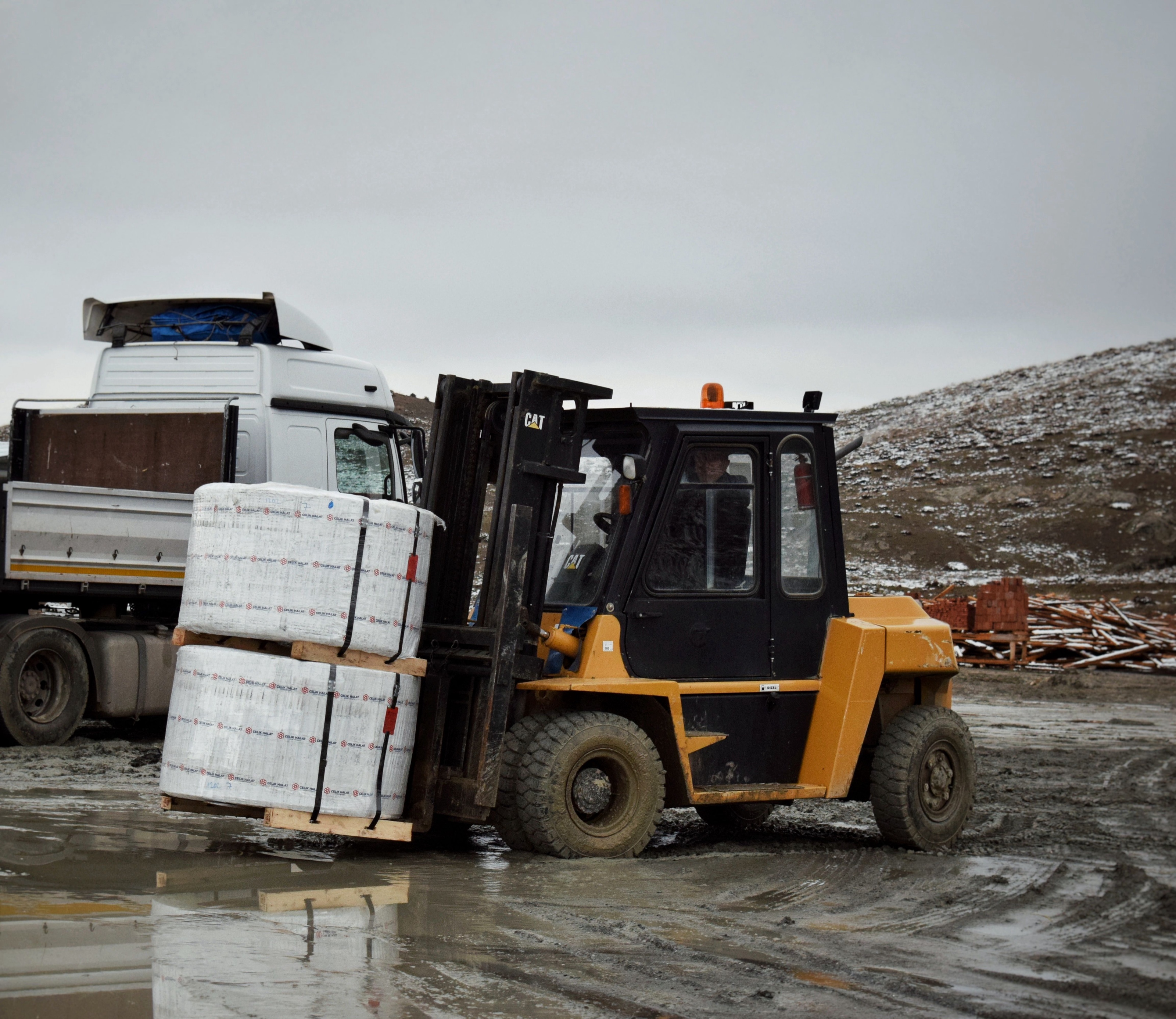 Forklift unloading palletized materials from a supplier delivery truck