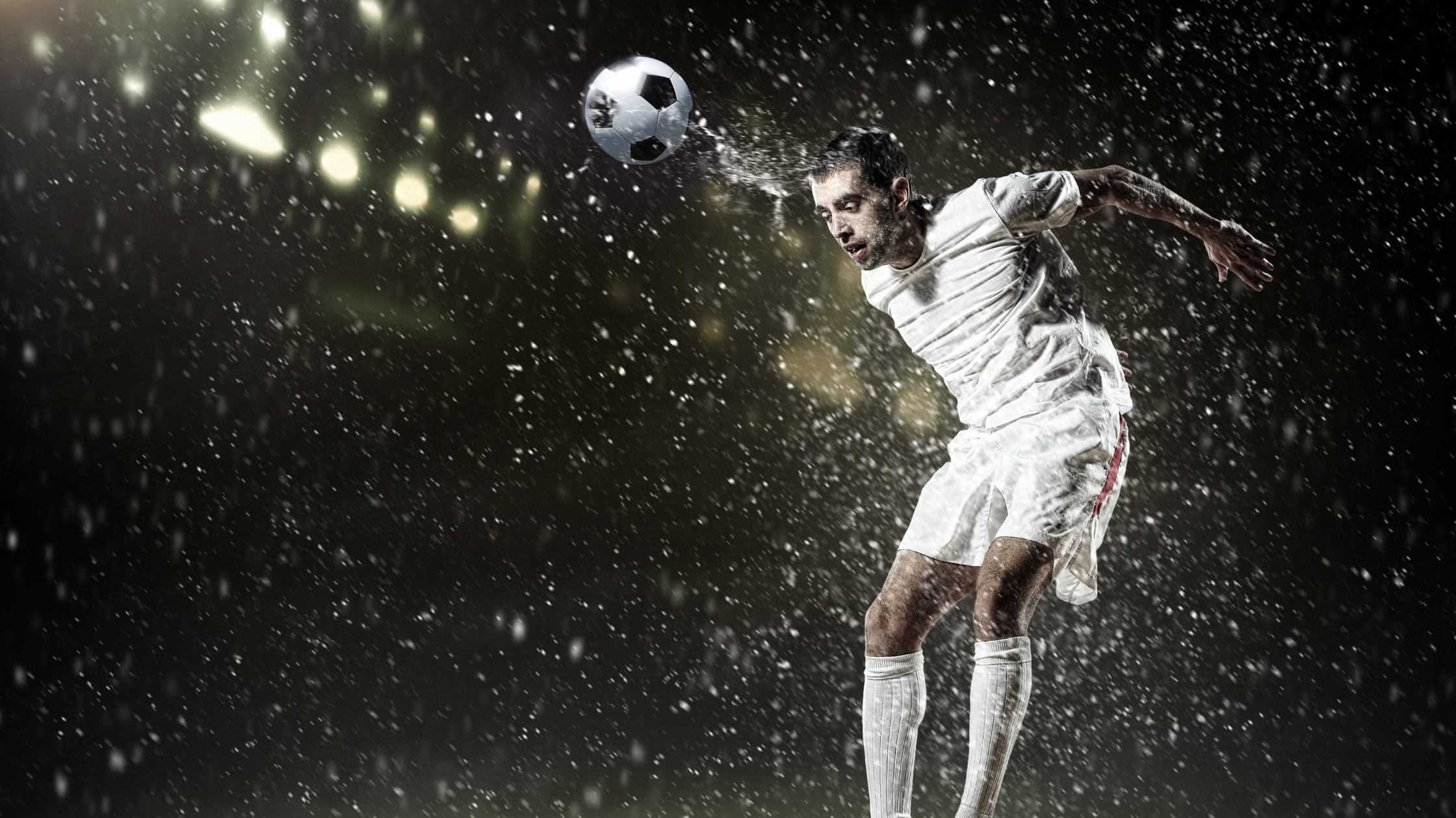 soccer player on the pitch surrounded by drops of water