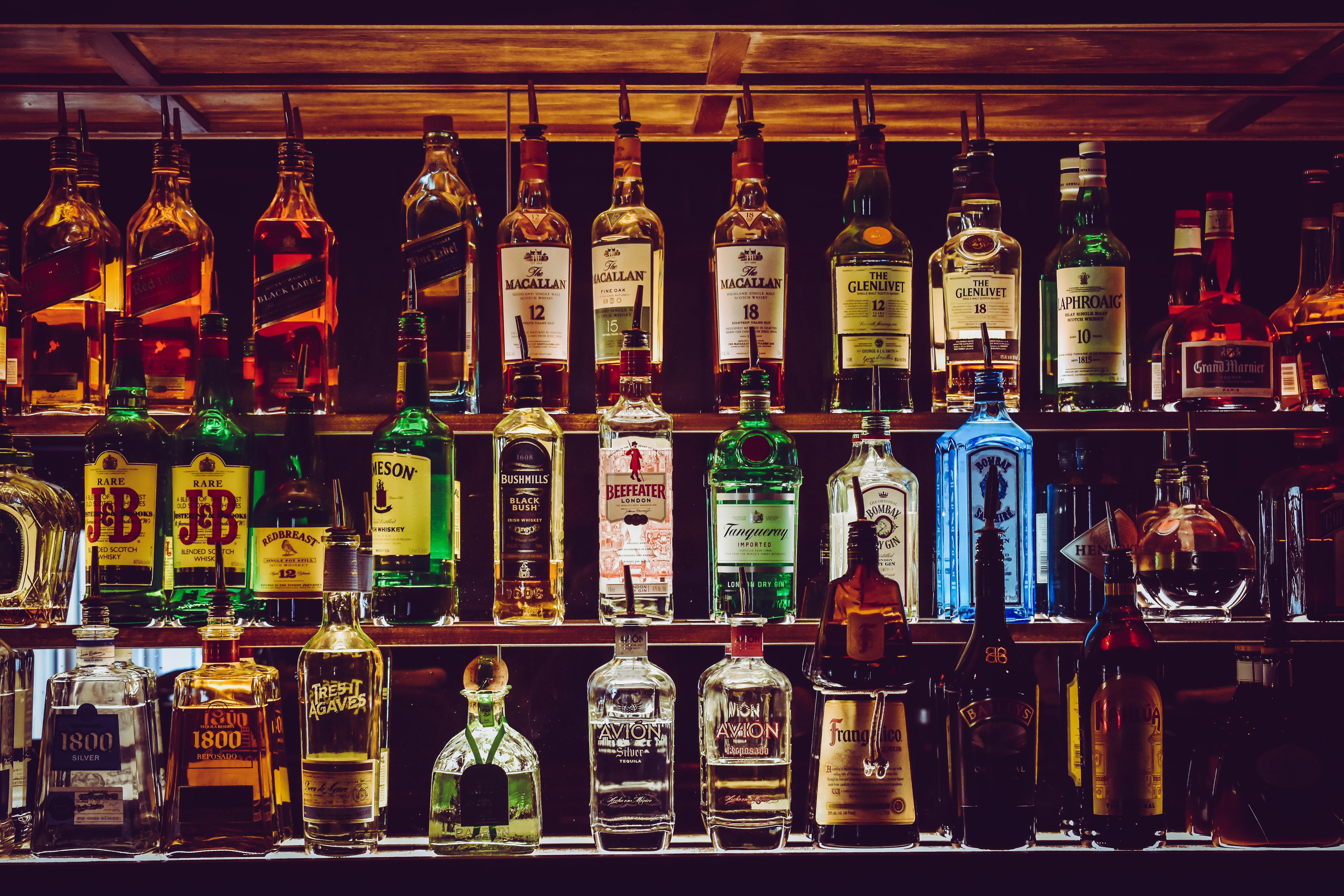 Shelves filled with various bottles of liquor at a bar.