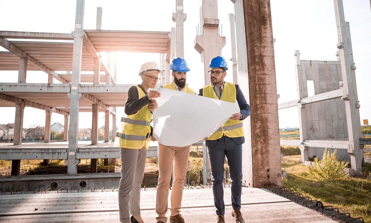 people with helmets at the construction site looking at the map
