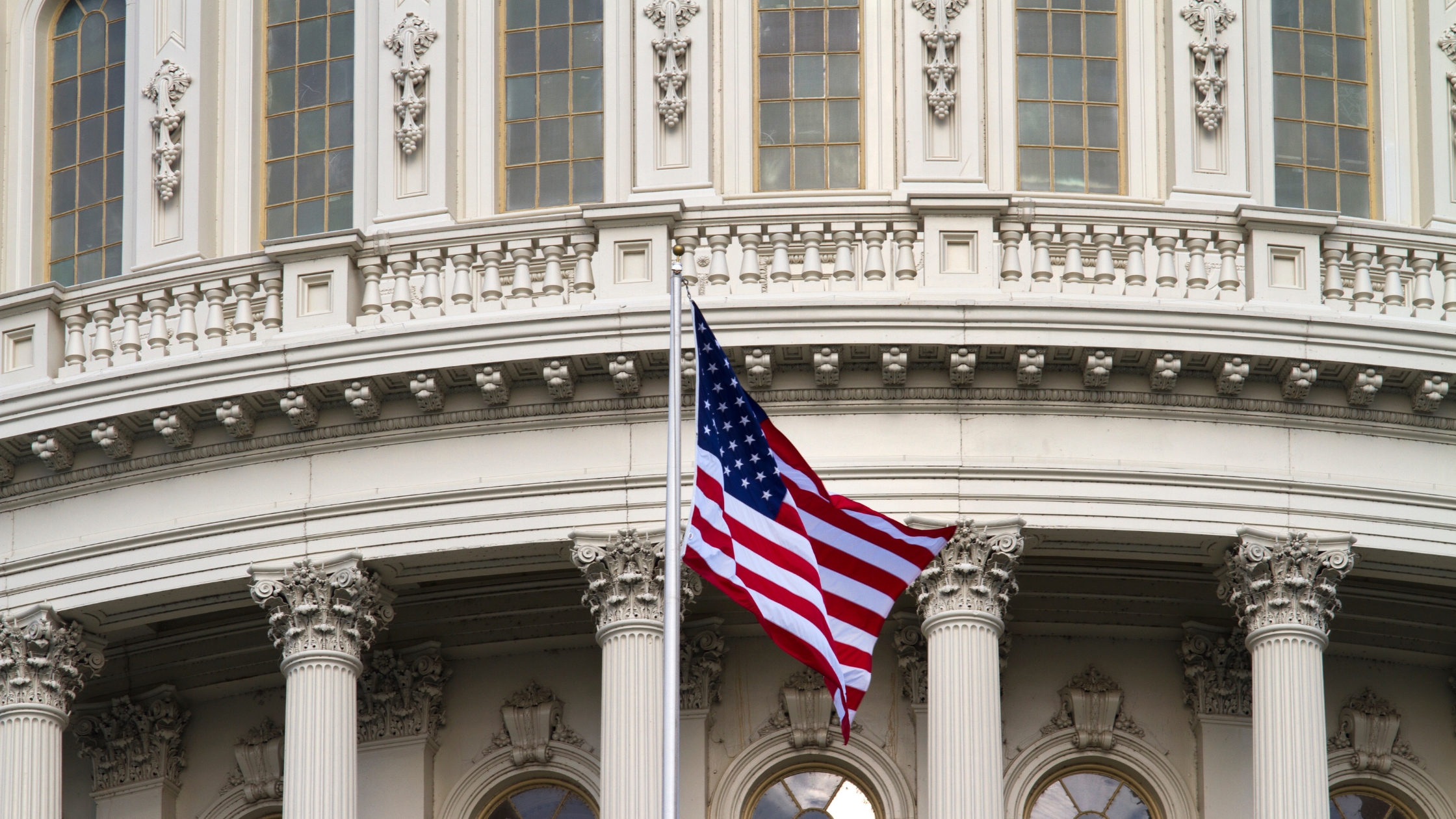 American flag waving in front of government building.