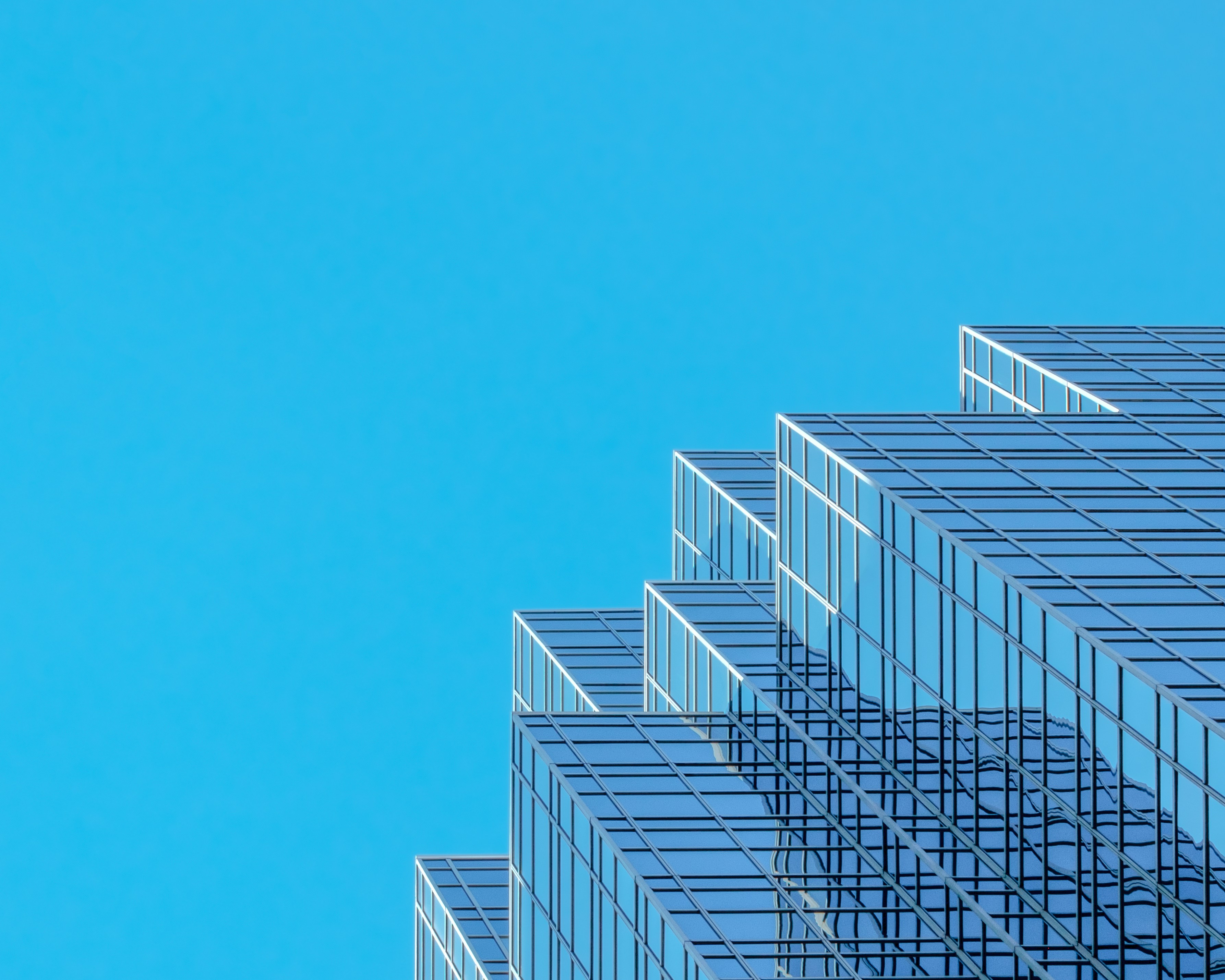 Modern glass office building with stepped architecture.