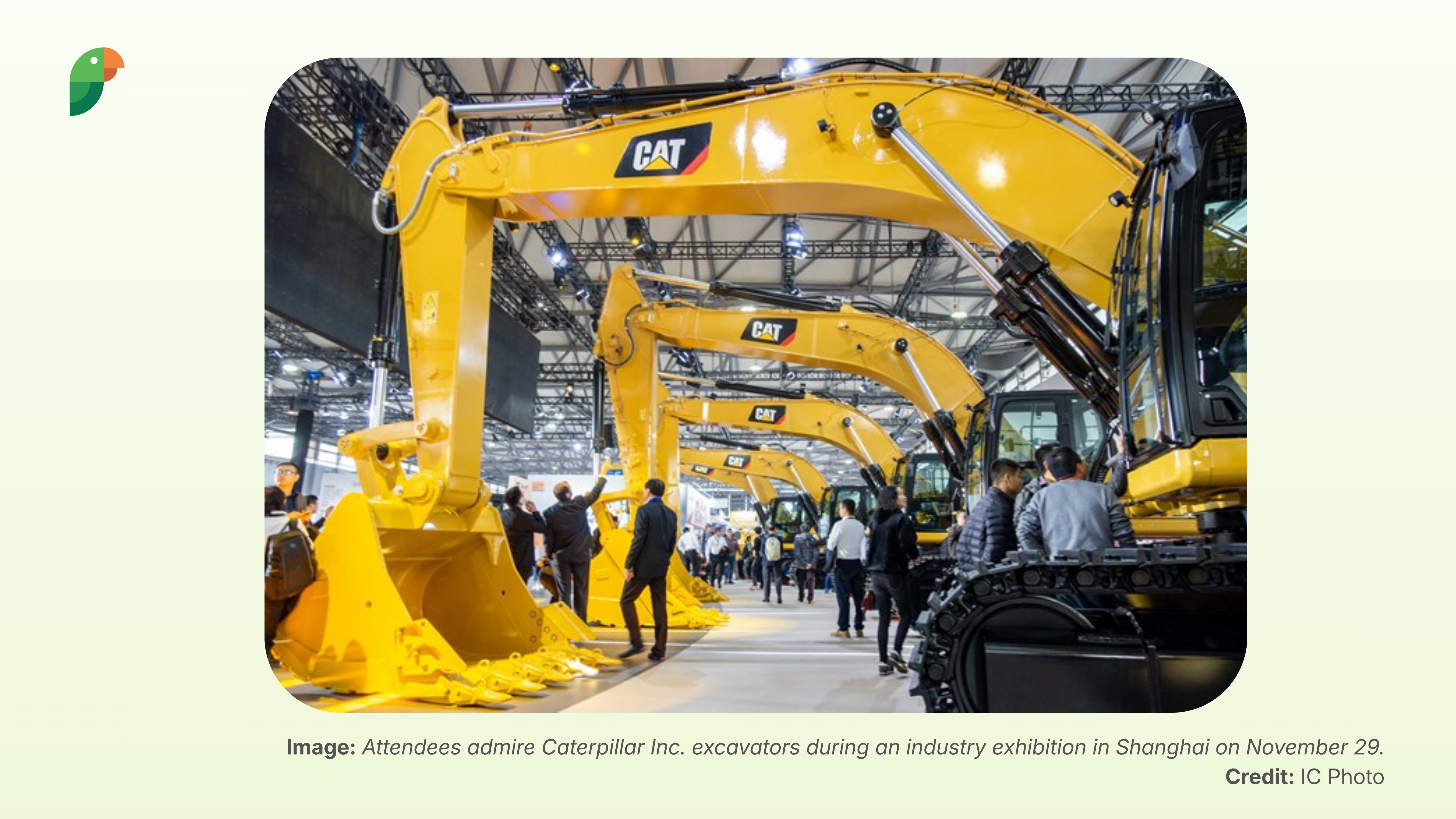 Visitors look at Caterpillar Inc excavators at an industry exhibition in Shanghai