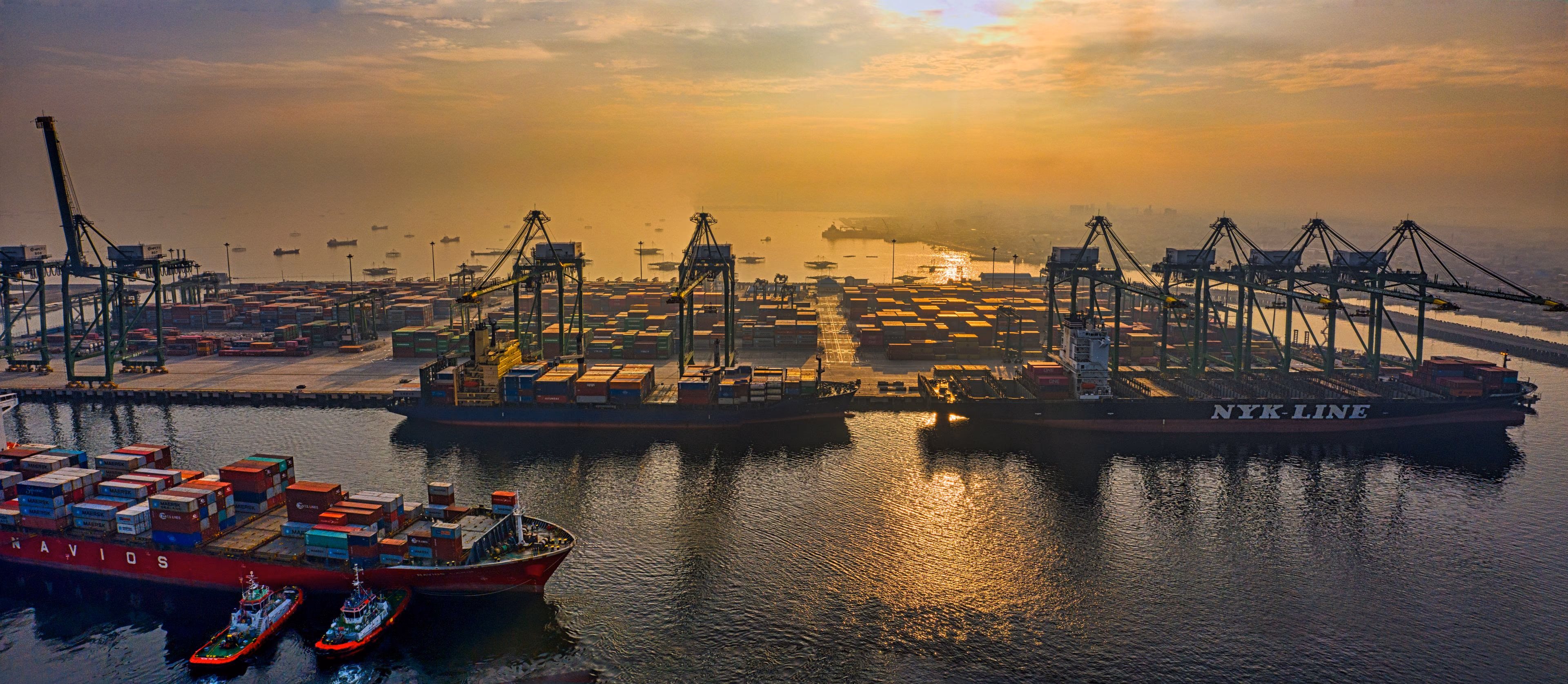 Panoramic aerial view of container ships and cranes at Jakarta’s port at dusk