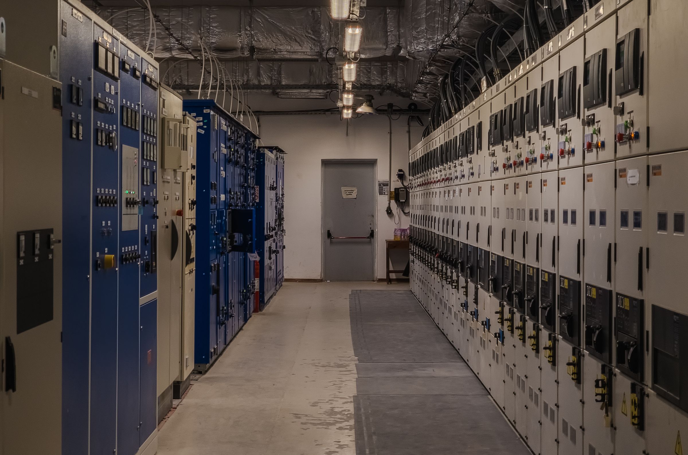 Corridor of electrical switchgear and control panels in a plant